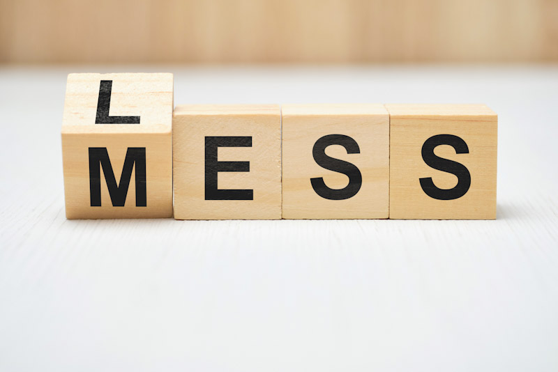 Lettered blocks reading, Less Mess