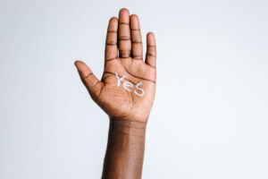 Raised hand with the word Yes on the palm