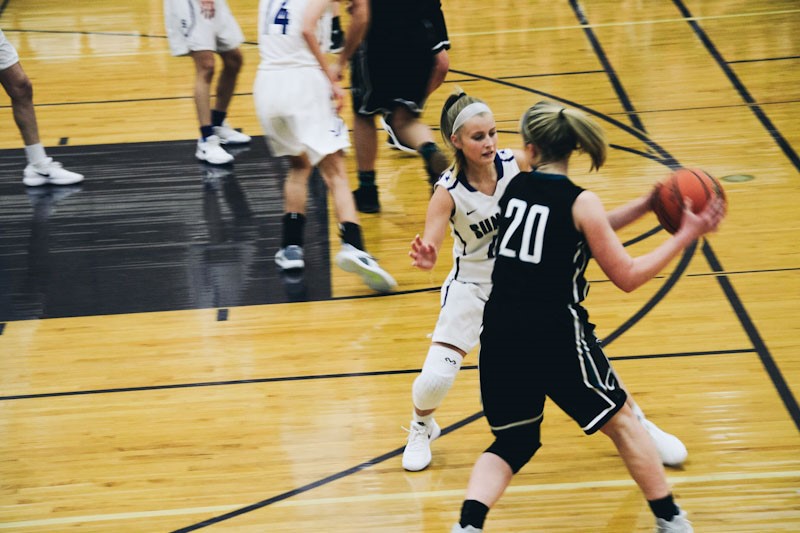 Woman guarding another player on the basketball court