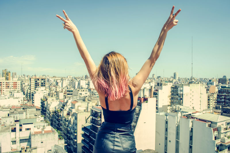 Woman on rooftop overlooking cityscape
