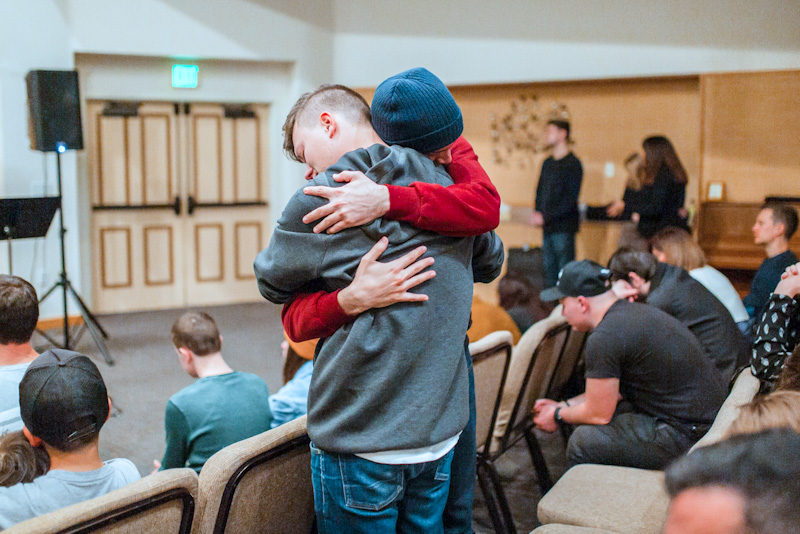 Two people hugging at addiction recovery meeting