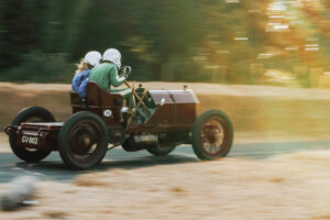 Man and woman speeding in an antique car