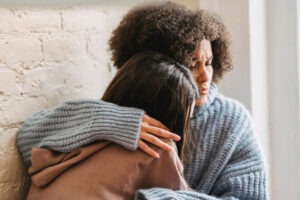 Woman consoling another woman