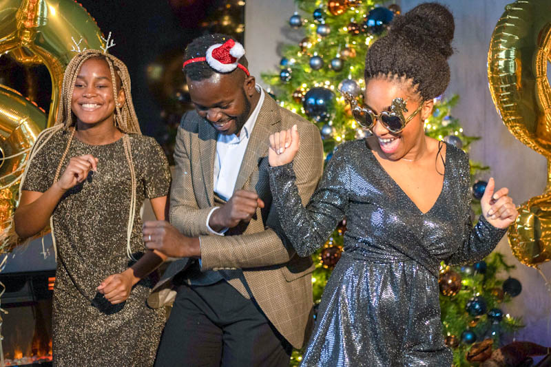 Two women and a man partying with holiday decorations