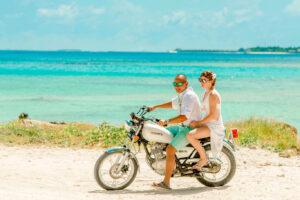 Sober couple riding a motorcycle on the beach