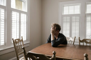 Depressed man sitting at wooden table